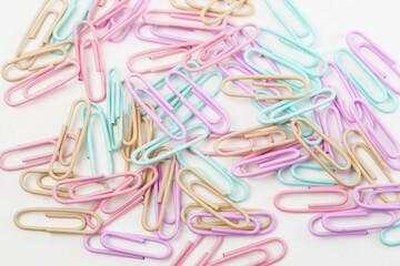 Multicolored paper clips close up isolated on white background. Stationery concept.