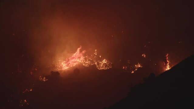 Wildfire burning on mountain side that was human caused in Utah as it works its way through the brush.