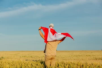 Crédence de cuisine en verre imprimé Canada Father with son and Canada flag on wheat field
