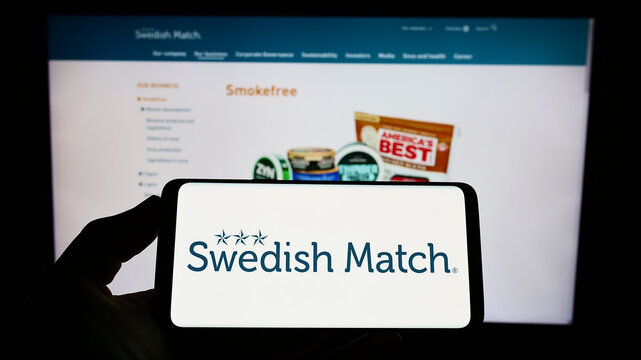 Stuttgart, Germany - 06-19-2022: Person holding smartphone with logo of tobacco company Swedish Match AB on screen in front of website. Focus on phone display.
