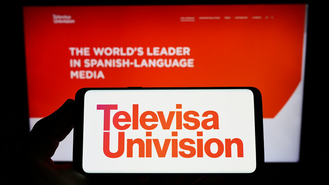 Stuttgart, Germany - 06-19-2022: Person holding smartphone with logo of media company TelevisaUnivision Inc. on screen in front of website. Focus on phone display.