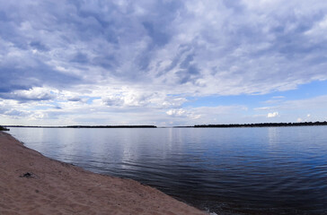 Reflection of the blue sky and clouds in the river. Skyline. Free beach.