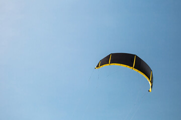 Black kite sail in the blue sky - copy space back for extreme sports