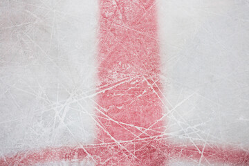 Close-up of a scratch on the ice of a hockey rink from skate blades - markings with red lines