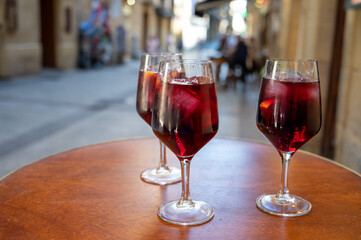 Glasses of cold sangria wine served outdoor in bar with view on old street in San Sebastian, Basque Country, Spain