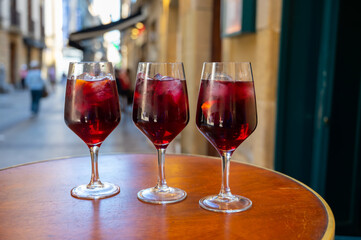 Glasses of cold sangria wine served outdoor in bar with view on old street in San Sebastian, Basque Country, Spain