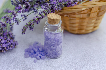Fototapeta na wymiar Lavender sea salt in a small transparent bottle and fresh lavender flowers. Lavender salt for spa treatments