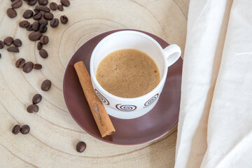 Coffee in porcelain cup and wooden base, ready to drink. Break concept.