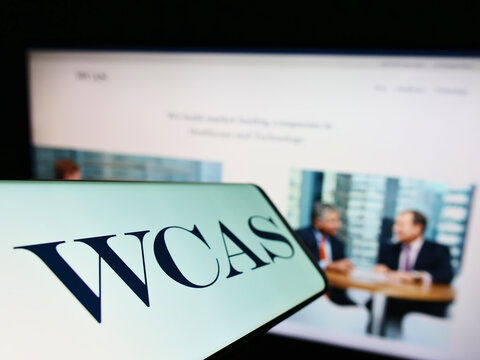 Stuttgart, Germany - 06-19-2022: Mobile phone with logo of company Welsh, Carson, Anderson and Stowe (WCAS) on screen in front of website. Focus on center-left of phone display.