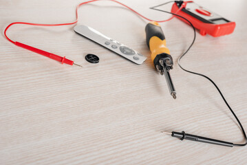 Network cable tester with remote control and screwdriver on wooden table