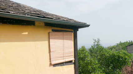 Ventana con persiana en esquina de casa rural © Darío Peña