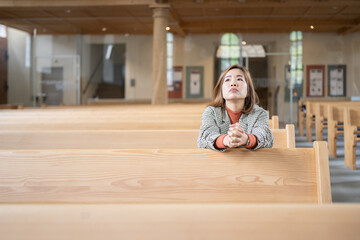A Christian female is sitting and praying.