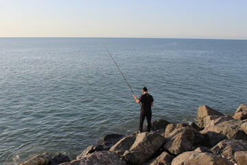 Fototapeta na wymiar person fishing on the beach