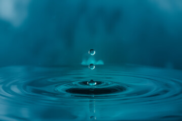 Fototapeta na wymiar water droplets splash, ripples on blue light effects background.