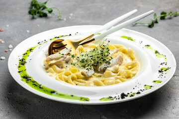 Pasta alfredo with chicken, Fettuccine alfredo in a creamy sauce with chicken, parmesan on white plate. Italian cuisine. Restaurant menu, dieting, cookbook recipe top view