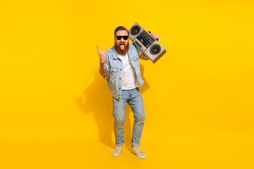 Fototapeta premium Full size portrait of careless rude person show heavy metal symbol isolated on yellow color background