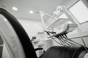 Dental equipment in the office of a dentist doctor with gray walls against the backdrop of bright light from the window.