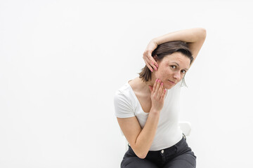 Photo of woman with dry skin touching her face on white background.