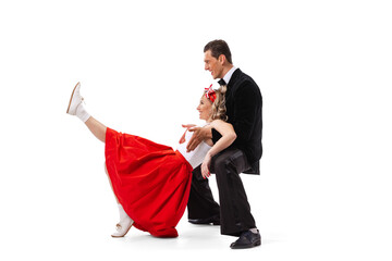 Dynamic portrait of dancing couple in vintage style clothes dancing, jumping isolated on white background. Art, music, fashion, dance shcool concept