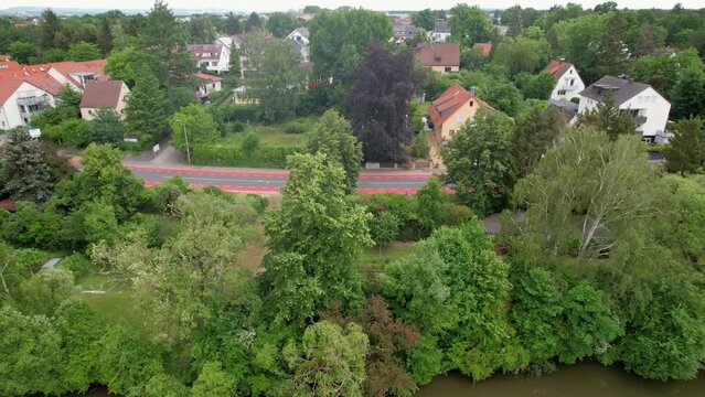 The drone flies over a rural landscape over the river Regnitz and the suburb of Erlangen-Bruck
