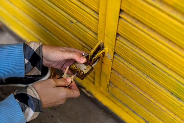 Businesswoman hands opening the lock on the door of her business.