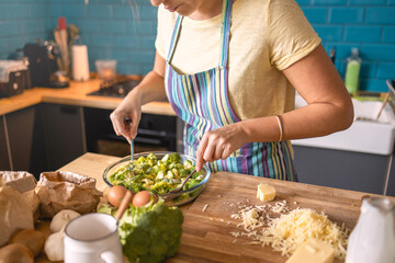 Young woman preparing lunch in her kitchen