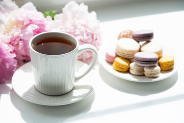 Сup of tea, peony and a cake on a blue background.	

