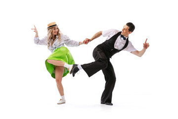 Excited young couple of dancers in vintage retro style outfits dancing social dance isolated on white background. Art, music, fashion, style concept