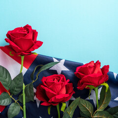 Concept of Independence day or Memorial day. American Flag over blue table background with red rose.