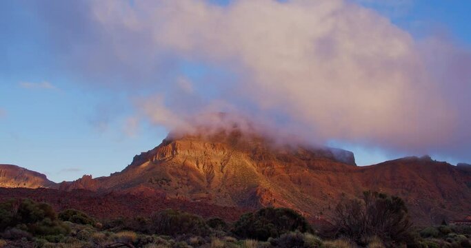 Lava scenery in Teide National Park, desert lanscape in sunset, Tenerife, Canary Islands. Colourful clouds, orange mountains.