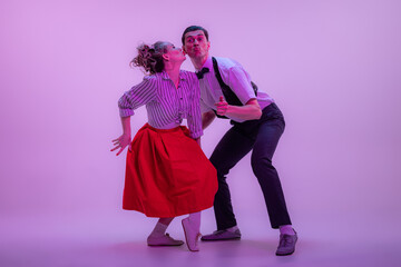 Stylish young man and pretty woman in vintage style outfits dancing retro dance isolated on very...