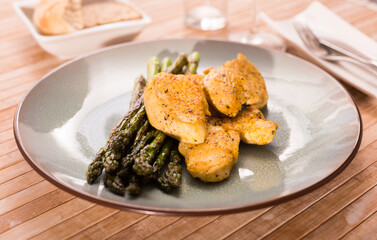 cooked dish. Chicken nuggets with green asparagus on plate
