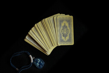 Tarot cards on a black background and a medallion with a natural stone