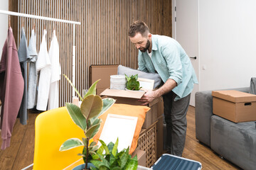 Hipster man with moving boxes in new modern apartment. Mature man unpacking things from boxes while moving in new apartment. 