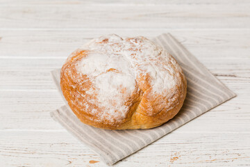 freshly baked bread with napkin on rustic table top view. Healthy white bread loaf isolated