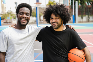 African friends playing basketball outdoor - Focus on left man face