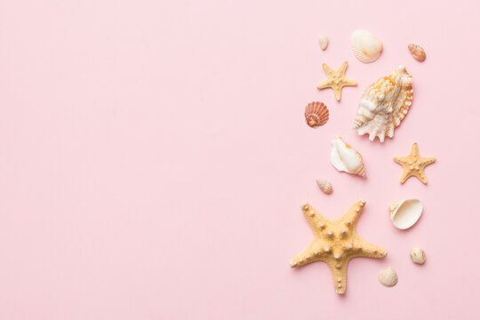 Summer time concept Flat lay composition with beautiful starfish and sea shells on colored table, top view with copy space for text