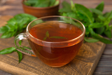 Cup of mint tea on table background. Green tea with fresh mint top view with copy space