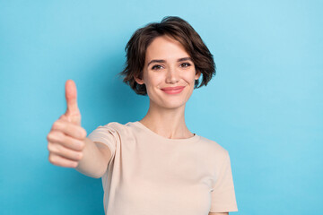 Photo of lovely cheery woman show you thumb up give compliment promote product isolated on blue...