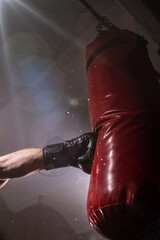 Close-up hand of boxer at the moment of impact on punching bag