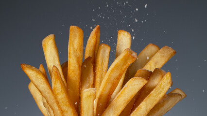 Detail Shot of adding Salt on French Fries, Close-up.