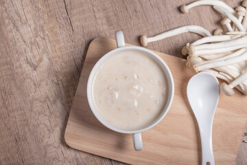Fototapeta na wymiar Mushroom cream soup in a white cup on the wooden floor.