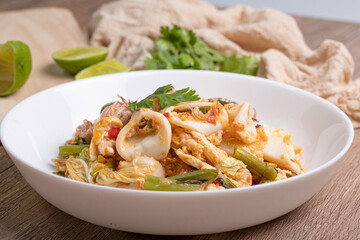 Sukiyaki dried squid Thai food in white bowl on wooden background