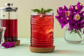 Freshly brewed iced red fruit tea on green table