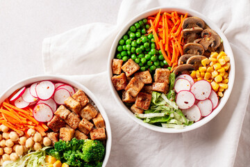 Vegan buddha bowl with tofu, colorful vegetables on base of brown rice.