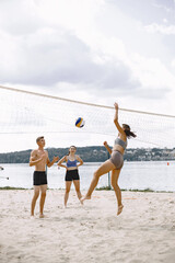 Young people playing volleyball on the beach