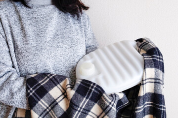 湯たんぽで温まるルームウエアを着た女性