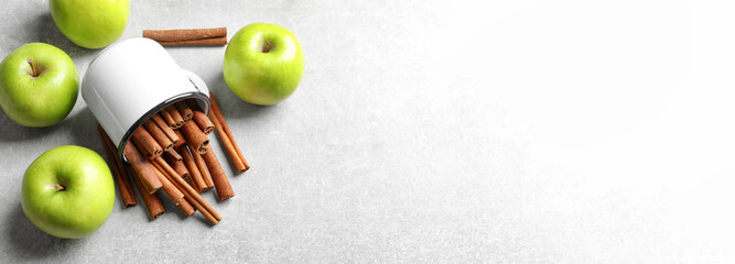 Fresh apples and mug with cinnamon sticks on table, top view with space for text. Banner design