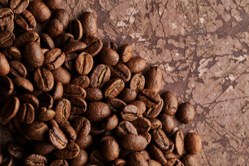 Roasted coffee beans isolated close up on brown grunge background