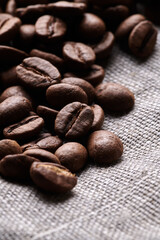 Roasted coffee beans decorated with burlap fabric close up creative background
